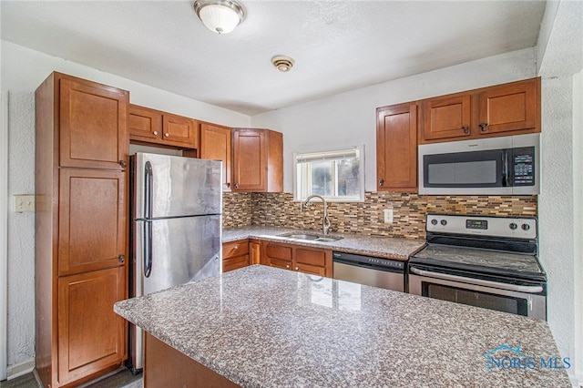 kitchen with a center island, stainless steel appliances, decorative backsplash, and sink