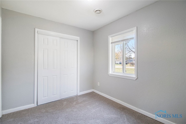 unfurnished bedroom with a closet and carpet flooring