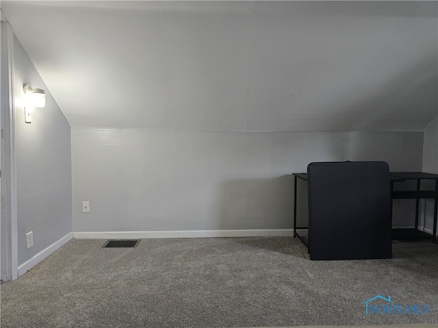 bonus room with vaulted ceiling and carpet floors