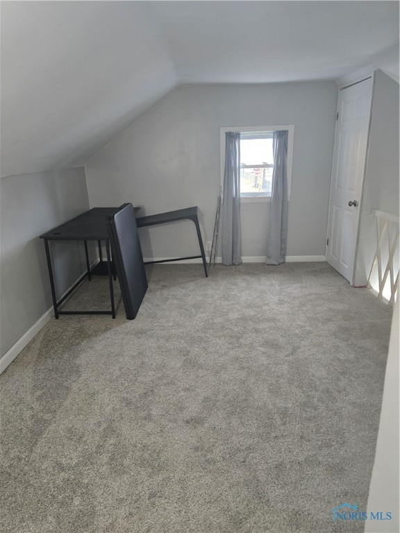 additional living space featuring lofted ceiling and carpet