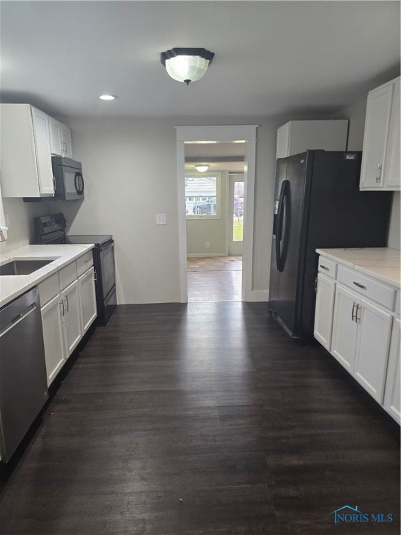 kitchen with sink, black appliances, white cabinetry, and dark hardwood / wood-style floors