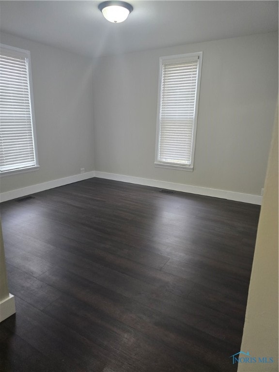 empty room featuring dark hardwood / wood-style flooring