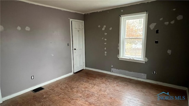 221 W Jackson St, Paulding, OH 45879 - empty room featuring healthy amount of natural light, wood finished floors, baseboards, and baseboard heating