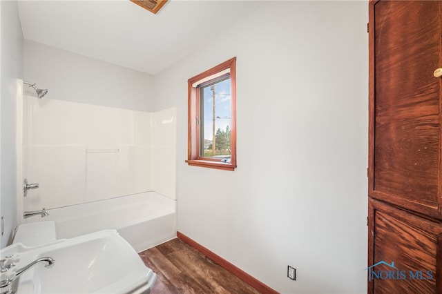 bathroom featuring sink, wood-type flooring, and shower / washtub combination