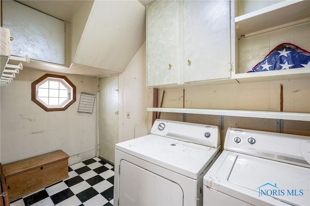 clothes washing area featuring independent washer and dryer and cabinets