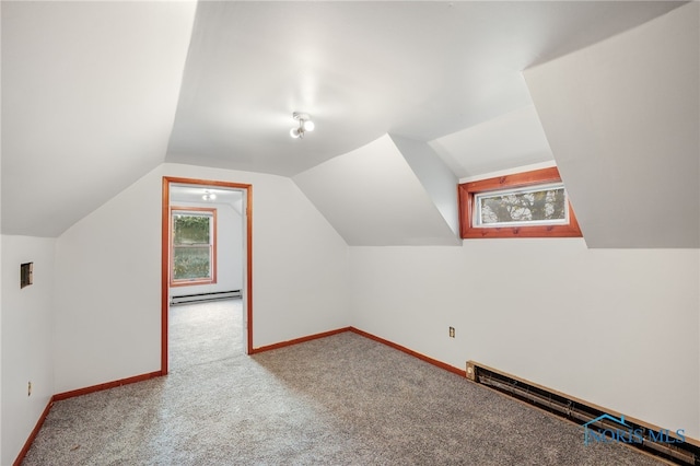 additional living space featuring a baseboard heating unit, vaulted ceiling, and carpet floors