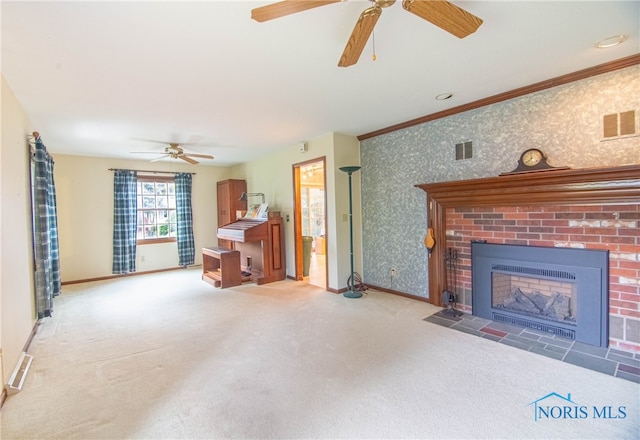 unfurnished living room featuring a fireplace, ceiling fan, carpet floors, and crown molding