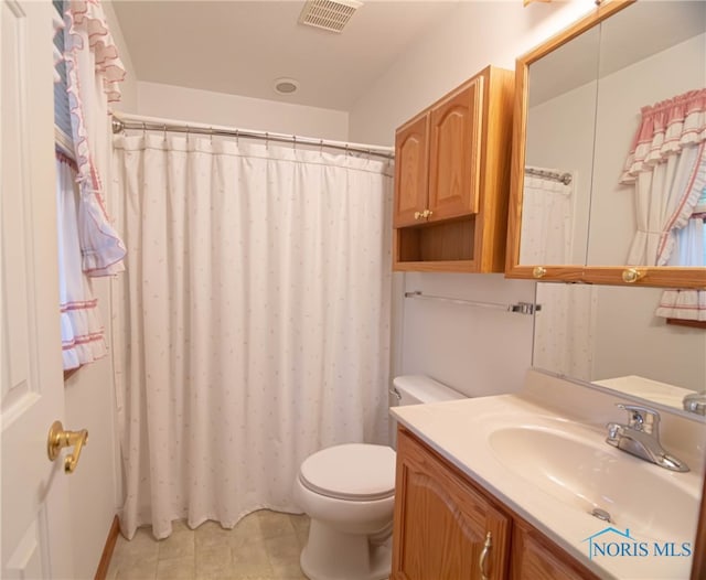 bathroom featuring tile patterned floors, vanity, and toilet