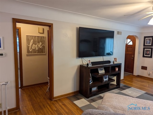 living room with ceiling fan, radiator heating unit, and dark hardwood / wood-style flooring