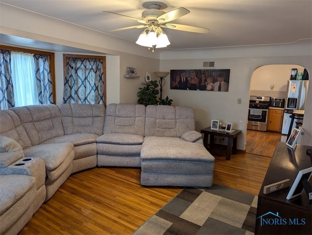 living room featuring wood-type flooring and ceiling fan