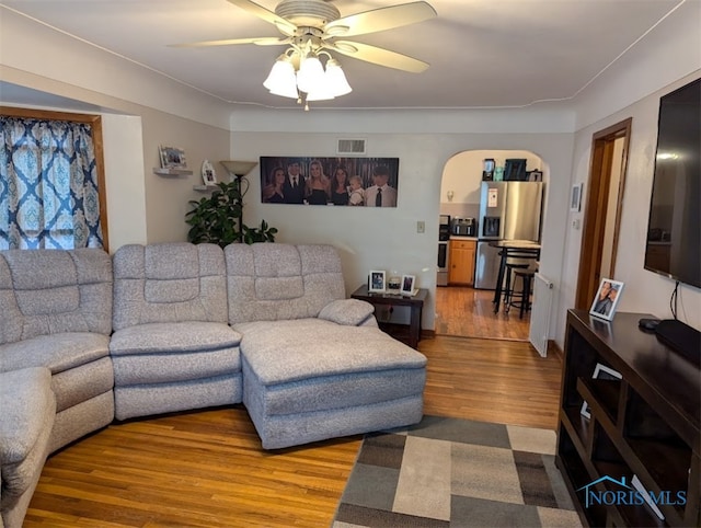 living room with wood-type flooring and ceiling fan