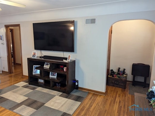 living room with wood-type flooring and ceiling fan