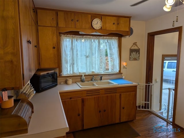 kitchen featuring dark wood-type flooring, ceiling fan, and sink