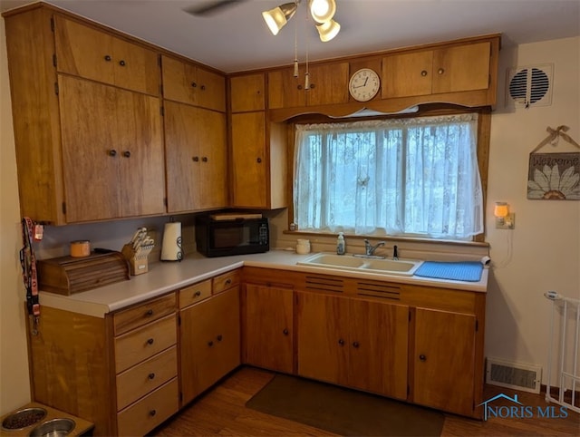 kitchen featuring dark wood-type flooring, radiator heating unit, ceiling fan, and sink