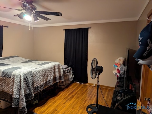 bedroom with hardwood / wood-style floors, ceiling fan, and ornamental molding