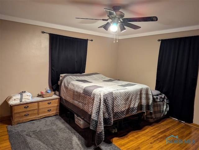 bedroom with ceiling fan, crown molding, and wood-type flooring