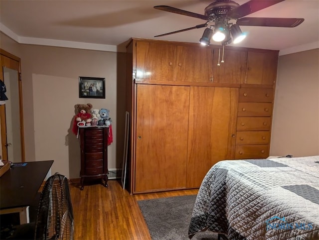 bedroom with ceiling fan, a closet, light wood-type flooring, and crown molding