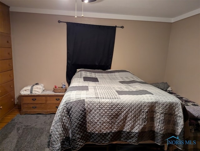 bedroom with wood-type flooring and crown molding