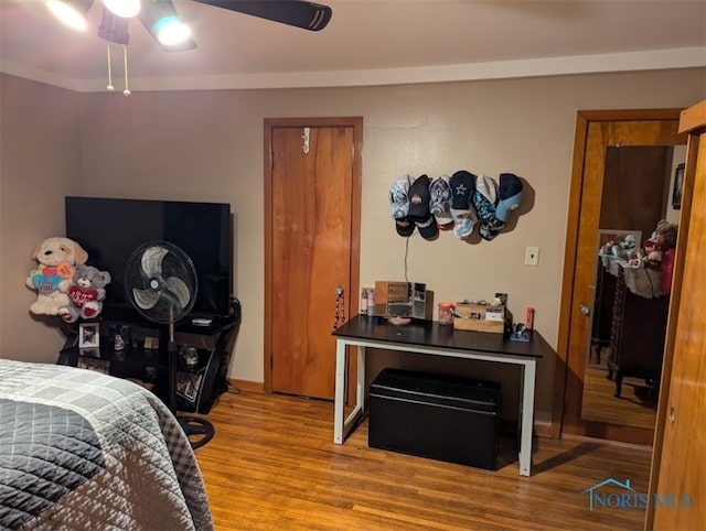 bedroom featuring ceiling fan, light wood-type flooring, and crown molding