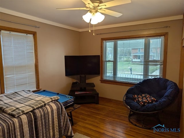 bedroom with ornamental molding, wood-type flooring, and ceiling fan