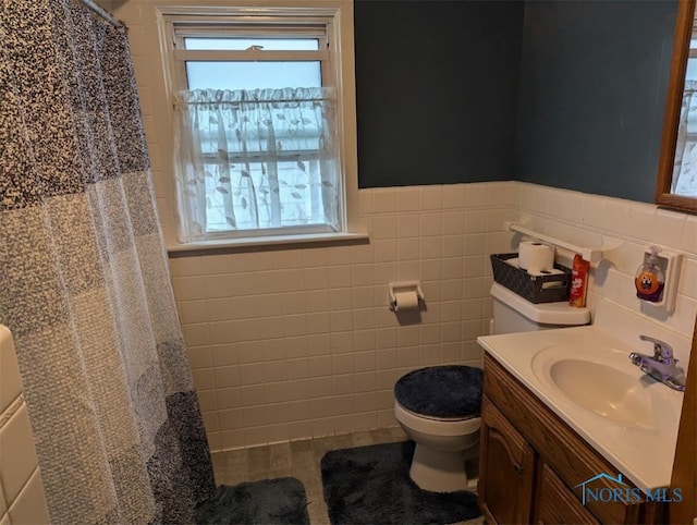 bathroom with tile walls, vanity, tile patterned flooring, curtained shower, and toilet