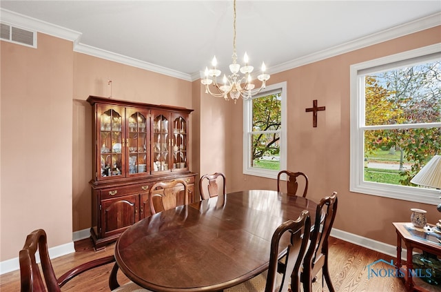 dining space with a wealth of natural light, hardwood / wood-style flooring, and a notable chandelier