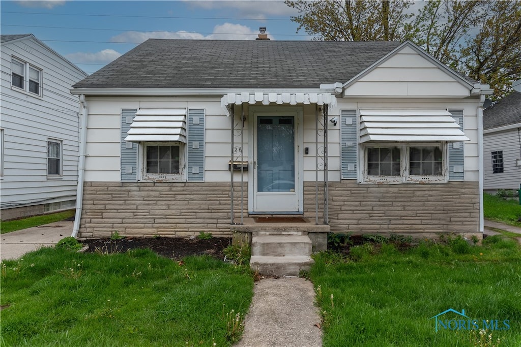 bungalow-style house with a front lawn