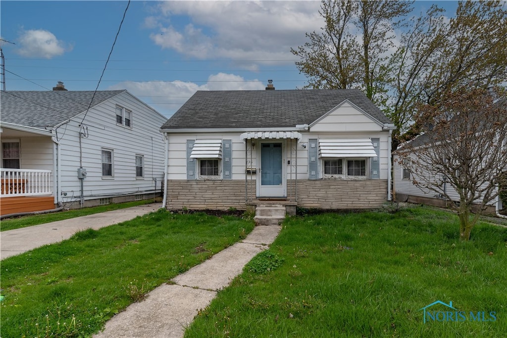 bungalow-style home featuring a front lawn