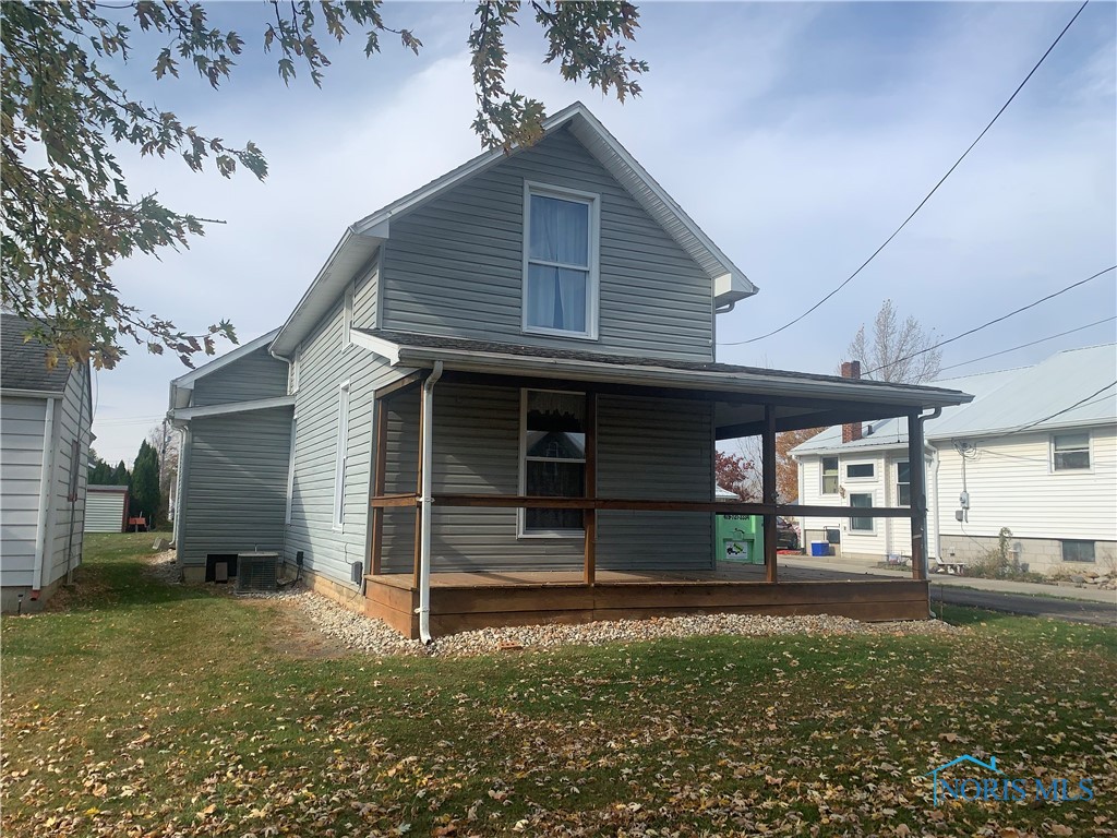 rear view of property featuring a porch, central AC, and a lawn