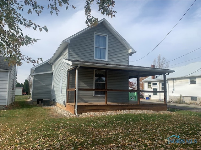 rear view of property featuring a porch, central AC, and a lawn