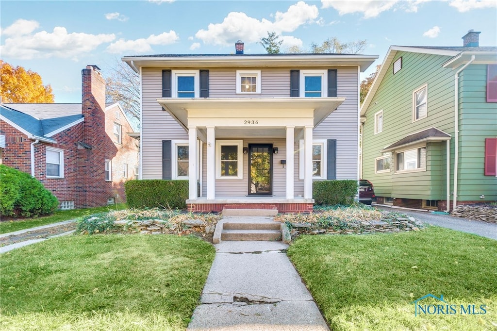 view of front of property with a porch and a front lawn