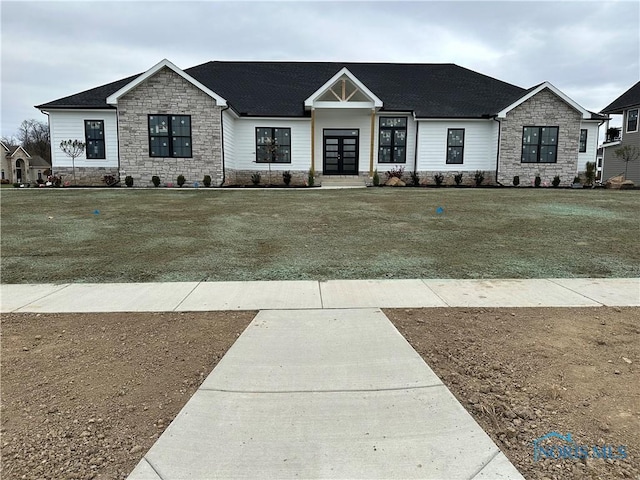 view of front facade featuring a front yard and french doors