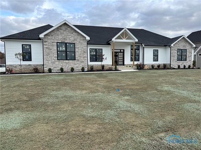 3640 Turtle Creek Dr, Perrysburg, OH 43551 - modern inspired farmhouse with stone siding, a shingled roof, and a front lawn