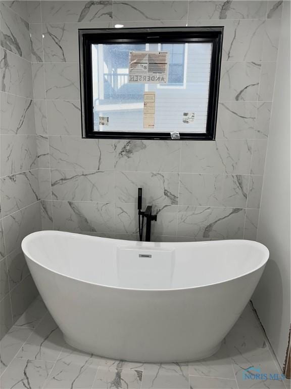 bathroom with a tub and plenty of natural light