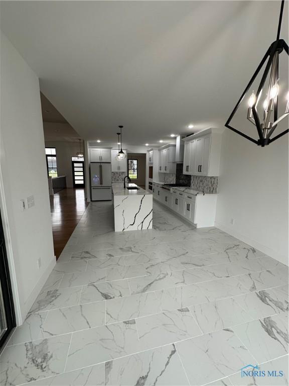 3640 Turtle Creek Dr, Perrysburg, OH 43551 - kitchen with stainless steel refrigerator, baseboards, a chandelier, decorative backsplash, and plenty of natural light