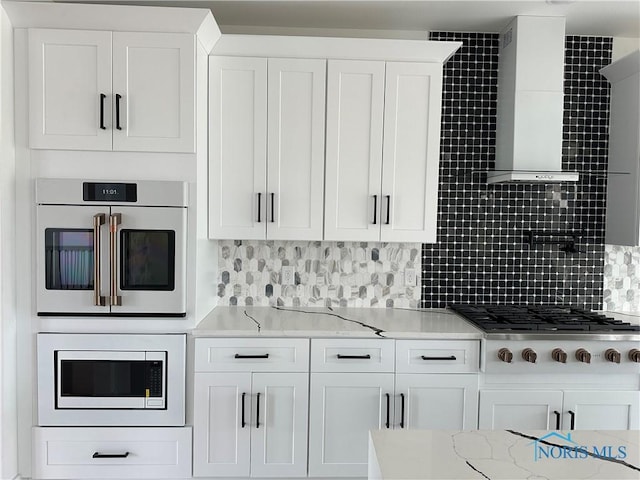 3640 Turtle Creek Dr, Perrysburg, OH 43551 - kitchen with built in microwave, stainless steel gas stovetop, wall chimney exhaust hood, tasteful backsplash, and white cabinetry
