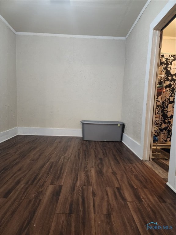 empty room with dark hardwood / wood-style floors and ornamental molding