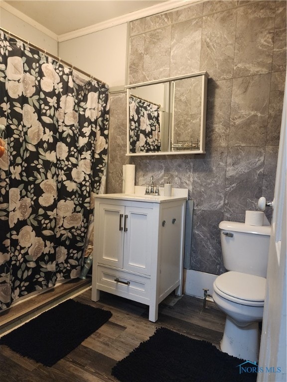 bathroom with hardwood / wood-style flooring, ornamental molding, vanity, toilet, and tile walls