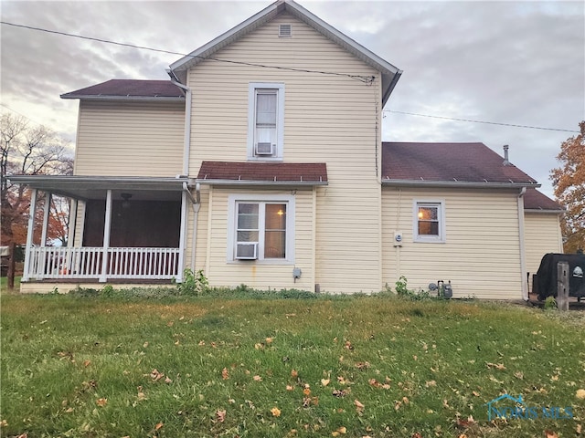 rear view of property featuring cooling unit and a yard