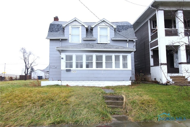 view of side of property featuring a balcony and a yard