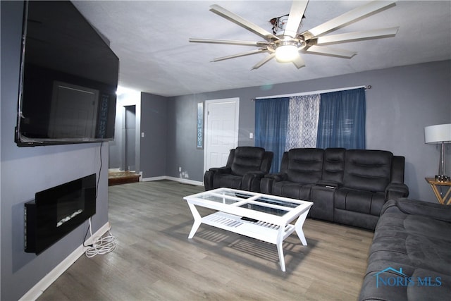 living room featuring wood-type flooring and ceiling fan