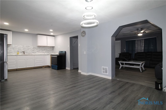 kitchen with ceiling fan, dark hardwood / wood-style floors, backsplash, white cabinets, and black electric range oven