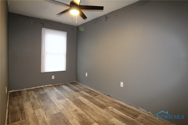 spare room with light wood-type flooring and ceiling fan