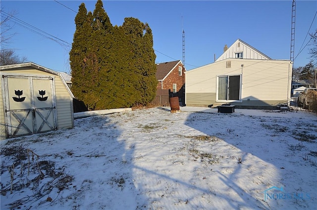 yard layered in snow featuring a storage unit