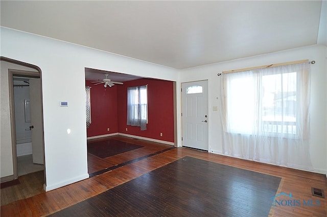 foyer entrance with ceiling fan and dark hardwood / wood-style flooring