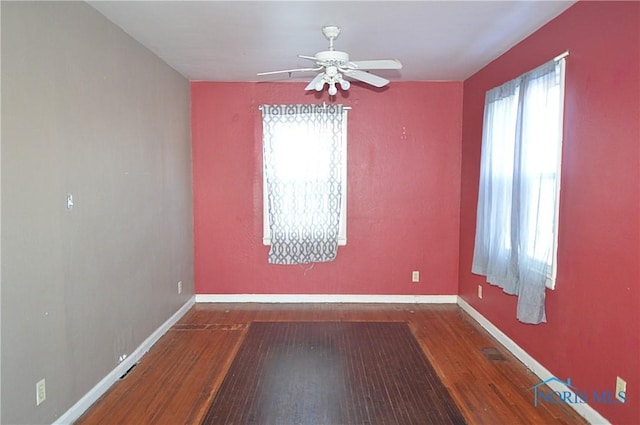 empty room with hardwood / wood-style flooring, ceiling fan, and plenty of natural light