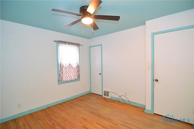 unfurnished room with ceiling fan and light wood-type flooring