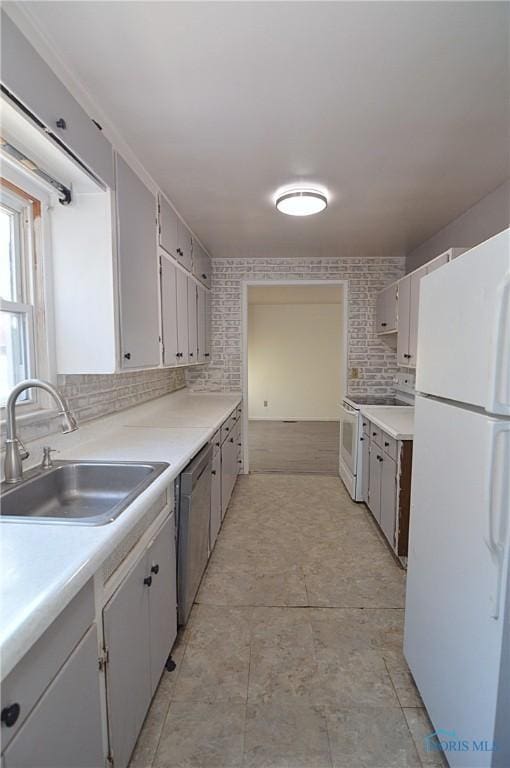 kitchen featuring tasteful backsplash, white cabinetry, sink, and white appliances