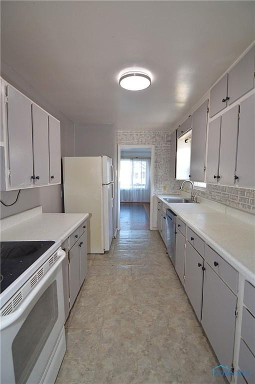 kitchen featuring tasteful backsplash, sink, white appliances, and white cabinets