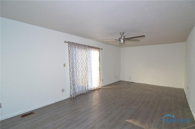 spare room featuring dark hardwood / wood-style floors, a textured ceiling, and ceiling fan